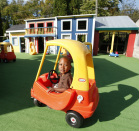 Child riding in a toy car